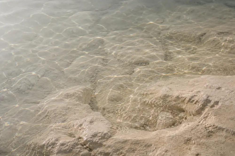 Clear shallow water rippling over a pale limestone shore