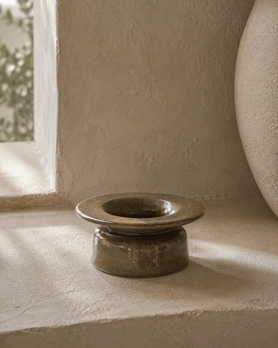 Olive-brown vessel with a wide flared rim in warm light