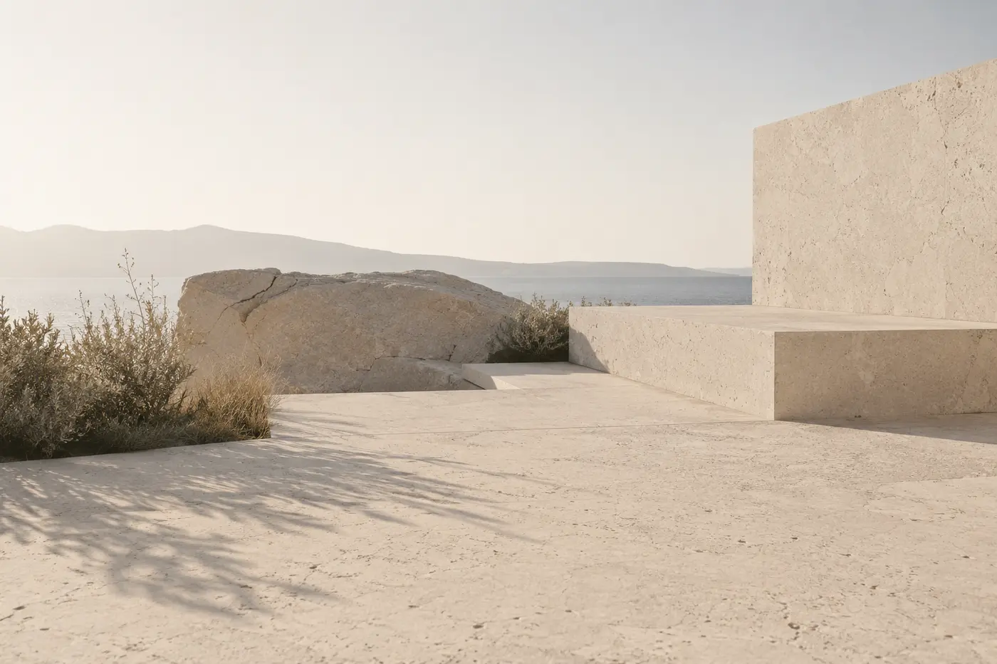A limestone monolith and carved stone benches above the sea in afternoon light